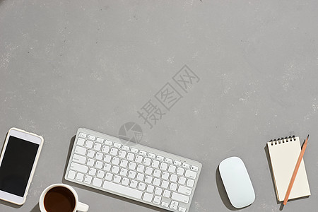 带有咖啡杯 笔记本 塑料厂 灰色背景的图形片板的办公桌工作空间顶部图片