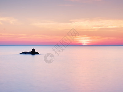 浪漫的海洋 泥沙从光滑的海中流出卵石日落天空海浪运动阳光石头海景戏剧性支撑图片