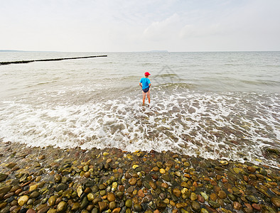 海滩上的孩子进入大海 孩子在海浪中玩耍海岸线假期男生热带娱乐游泳蓝色海洋农奴旅行图片