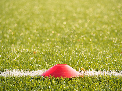 在足球场被绘的白色线上的明亮的红色塑料锥体 塑胶足球绿草坪操场图片