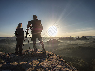 几位观光客拍摄山地和天空背景照片相机自由背包女性旅游爱好爬坡旅行女士摄影师图片
