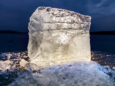 深色反光地面上的冰块 发光的碎冰和雪花片图片