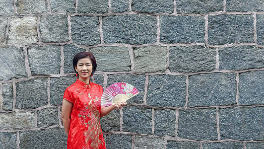 穿中国传统石墙服装的单身女旅游女性游客假期独奏新年建筑学民族旅行民间折扇衣服幸福图片