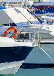 停泊在港口的游艇 游艇和摩托艇的特写 炎热的一天 码头的蓝水 蓝天梯子假期运动天堂车轮驾驶运输奢华活力支撑背景图片