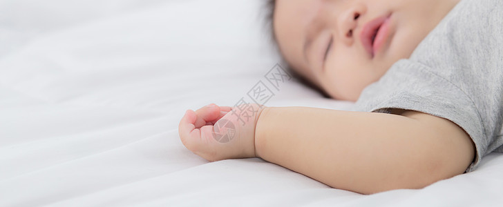 睡在家里卧室床上的亚洲小女婴的肖像 新生儿在舒适和放松的情况下打盹 睡前的婴儿纯真 快乐的幼儿可爱 孩子的成长和情感 在室内房间图片