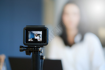 商业女性或博客在数码摄影机和现场直播中录制 vlog自由职业者屏幕网络训练互联网营销照片微笑播送教育图片