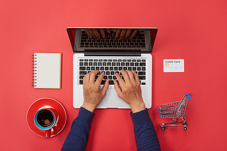 男子手在膝上型键盘上打字 红色背景带空白屏幕监视器顾客电脑技术桌子商务店铺办公室信用购物销售图片