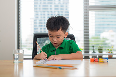 可爱的男孩在用彩色铅笔画画作业孩子童年家庭白色写作桌子学习教育学校图片