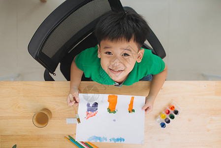 小男孩在桌子上画画白色孩子铅笔绘画教育童年蜡笔艺术画家学习图片
