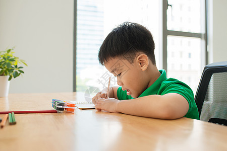 可爱的微笑男孩做作业 涂色 写作和绘画 孩子们画画 孩子们画画 在图书馆看书的学龄前儿童 五颜六色的铅笔和纸在桌子上 有创意的男图片