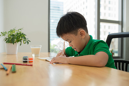 可爱的微笑男孩做作业 涂色 写作和绘画 孩子们画画 孩子们画画 在图书馆看书的学龄前儿童 五颜六色的铅笔和纸在桌子上 有创意的男图片