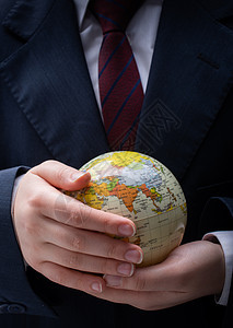 手里拿着地球仪模型的人技术力量科学手指人士全球化全世界教育男人金融图片