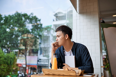 男人坐在咖啡店里 想着面包和茶时间男性日记店铺电话潮人手机商业咖啡杯子餐厅图片