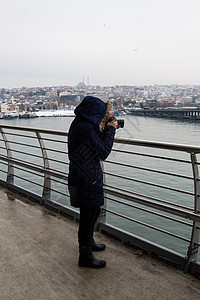 在桥的户外配有Dslr摄像头的旅游女摄影师拍照金角镜头女孩闲暇假期女士工作城市旅行图片