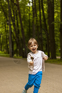 可爱的小男孩在一根棍子上拿着一个大圆棒棒糖 快乐的情绪 适合小孩子的糖果 夏季户外活动 有糖糖的学龄前儿童彩虹童年家庭男生情感微图片