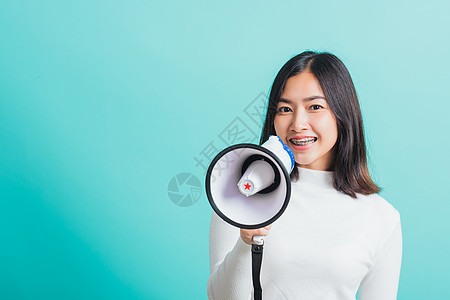 女人笑着 她拿着扩音器做宣布蓝色毛衣说话女孩扬声器女士嗓音青少年公告喇叭图片