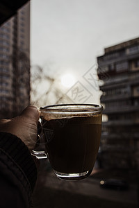 清晨的茶杯 在黎明的背景中 有咖啡在手边图片