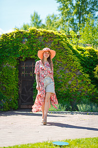 穿着淡夏日服的迷人女孩和佩雷奥帽正在绿色公园行走 享受阳光明媚的暑假闲暇女性太阳裙子快乐喜悦晴天舞蹈花园公园图片