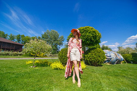 穿着淡夏日服的迷人女孩和佩雷奥帽正在绿色公园行走 享受阳光明媚的暑假太阳魅力成人情感帽子草地晴天闲暇幸福自由图片