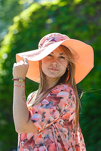 穿着淡夏日服的迷人女孩和佩雷奥帽正在绿色公园行走 享受阳光明媚的暑假微笑魅力女性花园情感帽子舞蹈女士草地喜悦图片