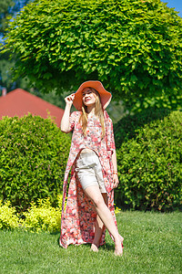 穿着淡夏日服的迷人女孩和佩雷奥帽正在绿色公园行走 享受阳光明媚的暑假情感微笑闲暇帽子自由成人晴天女士花园女性图片
