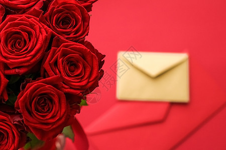 情人节的情书和送花服务 红色背景的豪华红玫瑰花团和纸信封红底通讯平铺假期邮政热情展示邀请函送货生日卡片背景图片