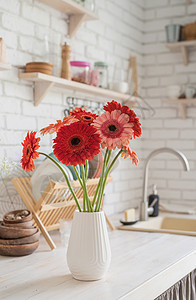 在木制厨房柜台的白色花瓶里 有红色和粉红色的家具粉色器具火炉乡村地面木头公寓房子住宅图片