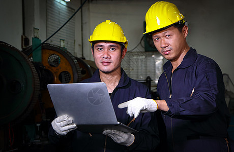 两名身着头盔制服的熟练亚洲工人正在使用计算机 笑声仓库男人团队职场工程师领班检查员职业工作控制图片