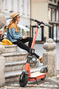 Ljubljana的旧中世纪历史城市在环保型电动摩托车上进行探索 女性游客到老城中心探险 坐在喷泉楼梯上休息和坐着地标学生女士太图片