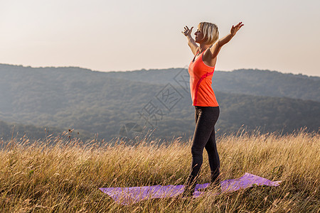 身体健康快乐的妇女 在用伸展的双臂锻炼后 享受大自然的放松运动装喜悦风景练习运动身体活力微笑瑜伽晴天图片