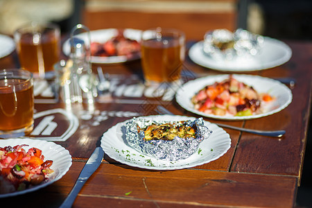 在咖啡馆的夏日阳台 木制桌子上装着食物的平板主菜盘子游客海滩蜜饯椅子杯子饮料小酒馆人行道图片