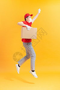 戴医疗面具和装箱保护手套的男子携带男性信使店铺餐厅纸板空气航班送货盒子运输男人命令图片