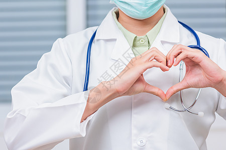 穿着白色大衣的女医生紧贴近身 站立在心脏手指形状上心脏病学测试生活专家有氧运动医院疾病微笑治疗外科图片