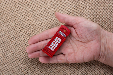 手握红色电话亭图标商业城市摊位民众旅行盒子电话王国艺术图片