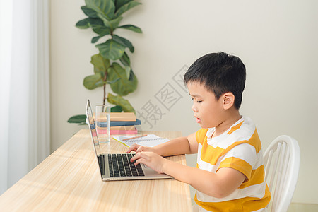 远程学习在线教育 一个男生在家学习并做学校作业图片