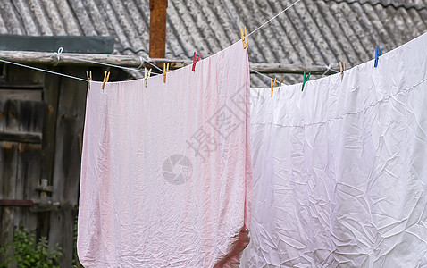 新洗的床单挂在户外的绳子上生态衬衫衣服织物空气蓝色快乐衣夹纺织品亚麻图片
