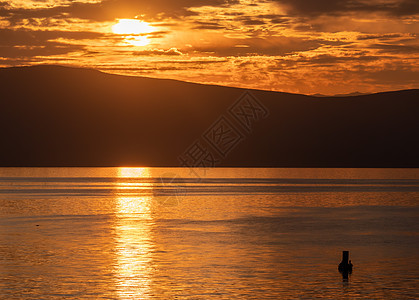 有 sunse 的美丽平静的湖天空日落场景晴天橙子海浪戏剧性地平线涟漪阳光图片