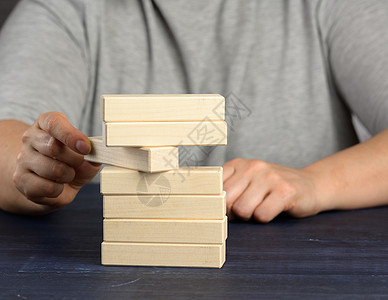 手从堆中拉出一块木块 平衡概念 情况控制金字塔风险组织危险商业游戏战略木头解决方案教育图片