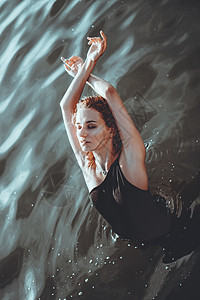 年轻美丽的女人站在水面上晴天女性海滩太阳假期身体泳装海洋闲暇年龄图片