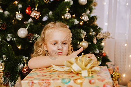 穿粉红裙子 在圣诞树背景上送礼物的可爱小女孩蕾丝庆典魔法房间婴儿展示假期奢华女孩们童年图片