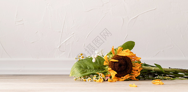地板上一束枯花朵悲伤死亡向日葵褪色植物群花束花瓣生活植物叶子图片