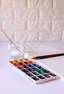 水彩画笔在玻璃和纸上的水在白色背景上 平面布局桌子蓝色学生创造力铅笔工作室想像力草图学校绘画图片