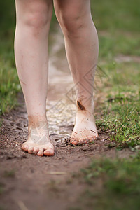 赤脚女孩在夏雨过后穿过水坑 走过一滩水花园飞溅跑步农村享受女儿公园小姑娘乐趣假期图片