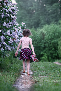 赤脚女孩在夏雨过后穿过水坑 走过一滩水树木喜悦享受跑步农村海滩想像力乐趣小姑娘村庄图片