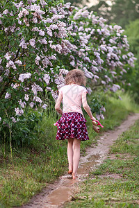 赤脚女孩在夏雨过后穿过水坑 走过一滩水外套乐趣紫色海滩童年飞溅跑步公园花园假期图片