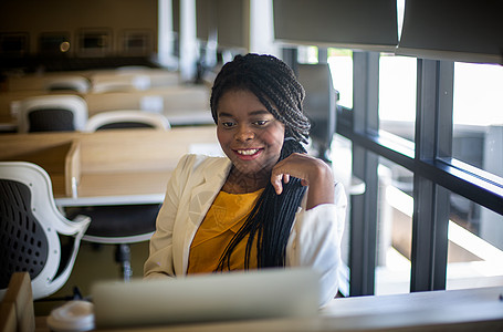 使用笔记本电脑工作的年轻非洲裔美国女性集中精力微笑雇员男人女士收入赚钱讨论同事风暴团体训练图片