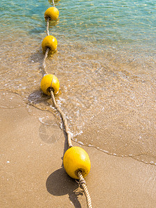 漂浮浮浮标和绳索分割海滩上的区域晴天安全红色白色海岸海浪海洋漂浮黄色假期图片