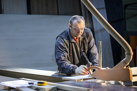 切割机旁的家具制造工人正在制作家具零件 家具制造劳动者木制品工具生产乐器工匠工作服机器加工木头图片