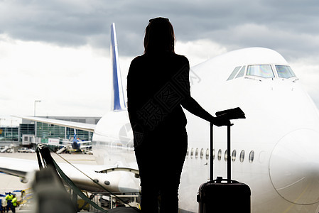 黑女人在机场大厅里寻找飞机的轮廓 错过或取消飞行的概念 笑声乘客空气游客飞机场压力行李孤独成人旅行运输图片