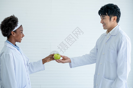 牛顿和苹果非裔美国年轻科学家将绿苹果赠予她的亚洲教师 在课堂或实验室学习前象征对老师的尊敬   action button背景